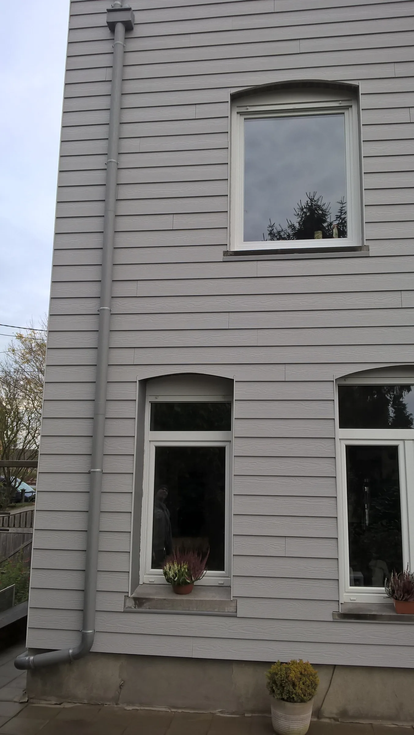 Façade recouverte d'un bardage à clins gris clair