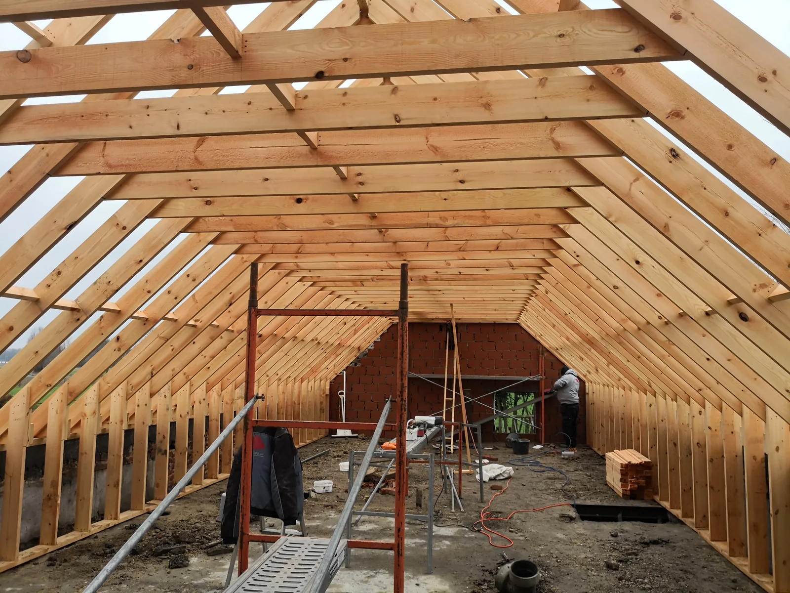 Charpente en bois vue de l'intérieur, chevrons et fermes en place